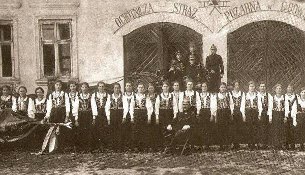 Istniejąca przy OSP Kobieca Drużyna Pożarnicza w czasie I Wojny Światowej przejęła obowiązki druhów. Zdjęcie wykonano przed budynkiem dawnej remizy w 1928r.
